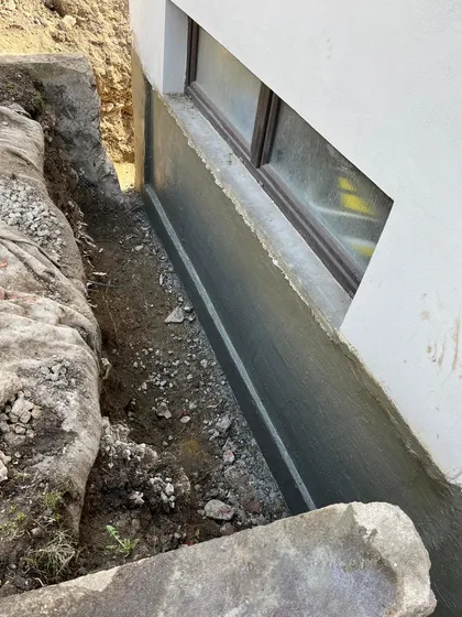 Nová hydroizolace na patě základové zdi v odkopané rýze