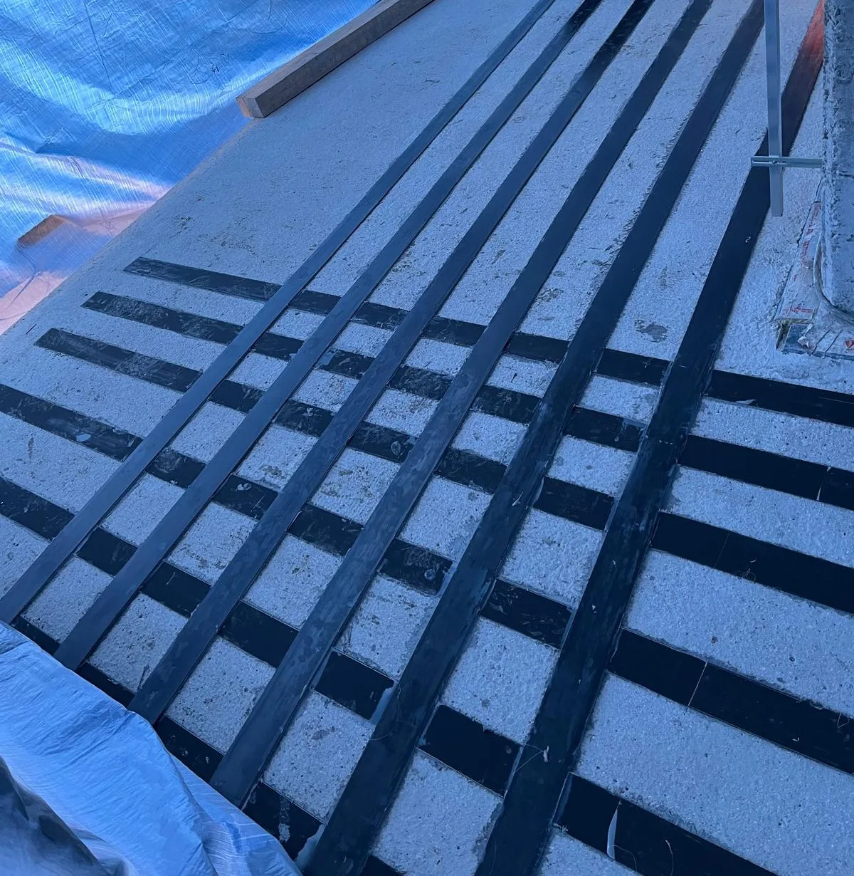Rastr uhlíkových lamel nalepený na betonové konstrukci pod zakrytím